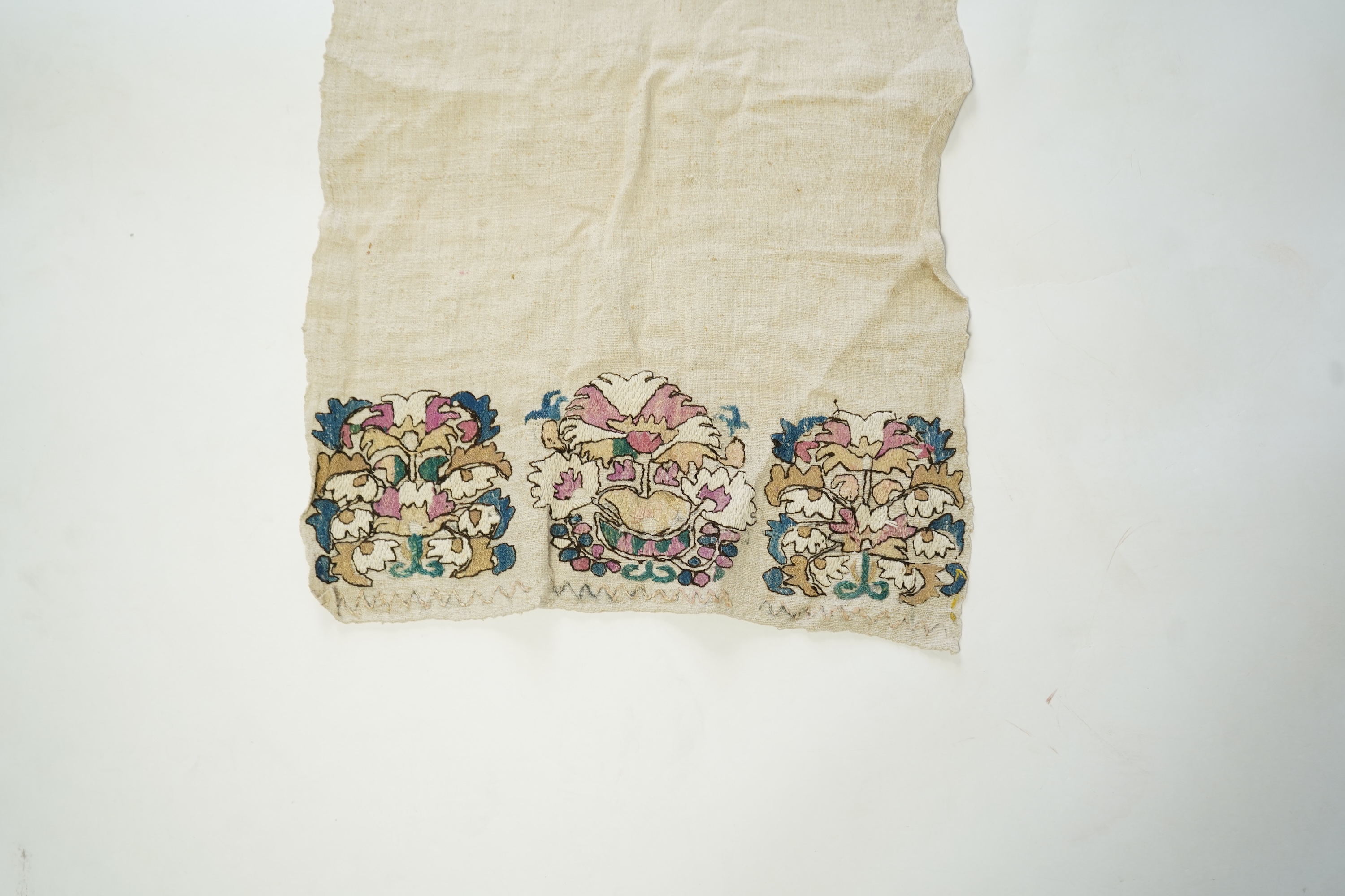 An early 20th century heavy hand woven linen Turkish towel, with coloured silk embroidered ends. 123cm long x 43cm wide. Condition - has two stains and some embroidery worn in places.